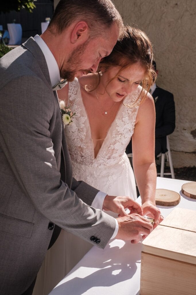 Hochzeitskrone Vor der bezaubernden Kulisse Niederösterreichs nehmen Braut und Bräutigam an einem ergreifenden Hochzeitsritual teil und versiegeln gemeinsam im Freien eine Holzkiste. Diese natürlichen Hochzeitsfotos fangen ihren bezaubernden Moment auf wunderschöne Weise ein, als sie ihre gemeinsame Reise beginnen.